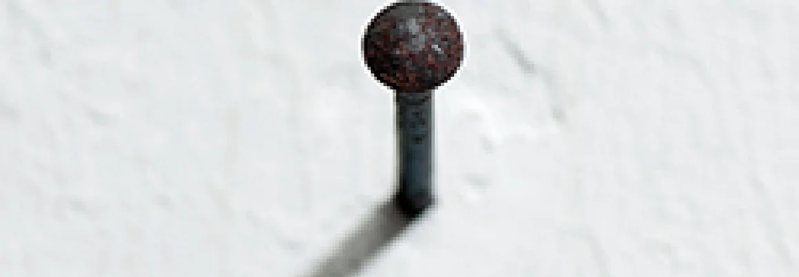 Nagel in weißer Wand